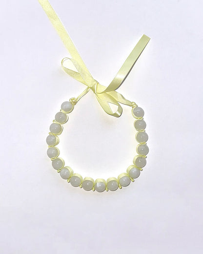 collar lazo amarillo con cuentas grandes blancas
