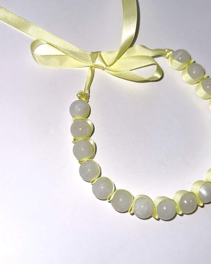 collar lazo amarillo con cuentas grandes blancas